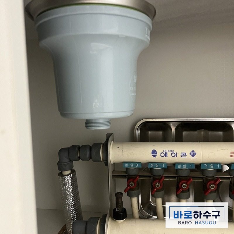 싱크대 하부장 안, 손상된 주름호스를 떼어 낸 배수통 아래 작업 전 모습 (안산 현장)