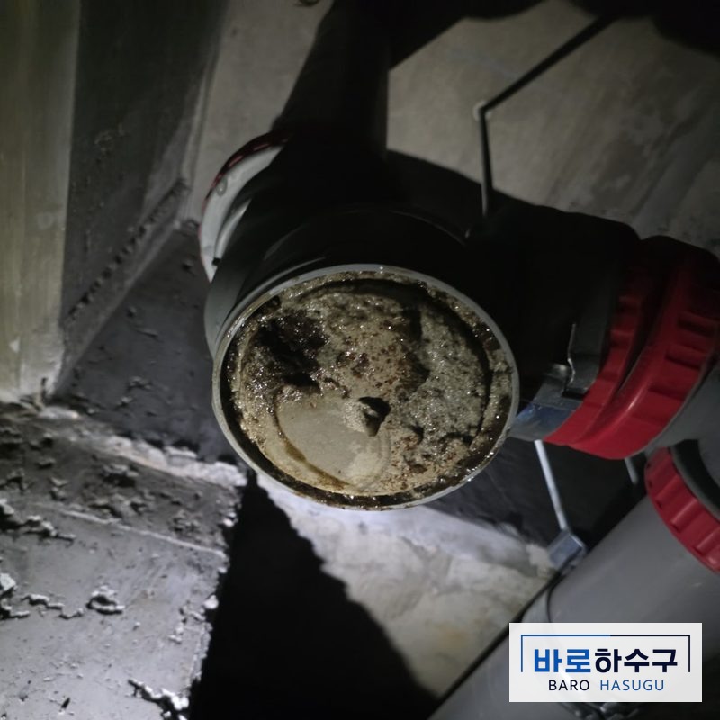 분리한 욕실 배관 단면에 굳은 시멘트가 가득 차 통로가 막혀 있는 작업 전 상태 (용인 현장)